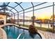 Screened-in pool and spa overlooking waterfront with dock; perfect for enjoying tranquil evenings and sunsets at 257 Lido Dr, Punta Gorda, FL 33950