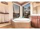 Corner soaking tub with jets situated under a corner window in a light and spacious bathroom at 257 Lido Dr, Punta Gorda, FL 33950