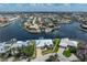 Aerial view of waterfront home with a metal roof and lush landscaping on a canal with a boat dock at 258 Venezia Ct, Punta Gorda, FL 33950