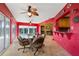 Bright, red Florida room with casual table set and view to the pool at 258 Venezia Ct, Punta Gorda, FL 33950
