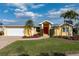 Charming single-story yellow home with a metal roof, a brick driveway, and lush landscaping at 258 Venezia Ct, Punta Gorda, FL 33950