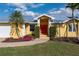 Inviting front exterior with colorful flowerbeds, lush landscaping, and a red front door at 258 Venezia Ct, Punta Gorda, FL 33950