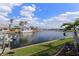 Serene water view showcasing a canal with boats, palm trees, and lush green landscaping at 258 Venezia Ct, Punta Gorda, FL 33950
