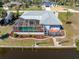 Aerial view of the property with a screened-in pool and a wooden deck overlooking the canal at 3024 Caribbean Dr, Punta Gorda, FL 33950