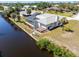 Aerial view featuring a waterfront property with screened pool, lush landscaping, and boat dock at 3024 Caribbean Dr, Punta Gorda, FL 33950