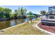 Picturesque waterfront backyard with lush greenery, boat lift, and canal views at 3024 Caribbean Dr, Punta Gorda, FL 33950