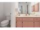 Bathroom featuring a pink vanity cabinet, a large mirror, and a white toilet at 3024 Caribbean Dr, Punta Gorda, FL 33950