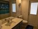 Bathroom features a modern vanity, toilet, and access to the backyard at 3024 Caribbean Dr, Punta Gorda, FL 33950