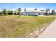 Spacious front yard with lush green grass, mature palm trees, and a well-maintained lawn at 3024 Caribbean Dr, Punta Gorda, FL 33950