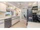Inviting kitchen with white cabinetry, ceiling fan, black appliances, and easy dining area access at 3024 Caribbean Dr, Punta Gorda, FL 33950