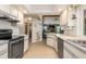 Traditional kitchen with appliances and wood floors, leading into the living area at 3024 Caribbean Dr, Punta Gorda, FL 33950