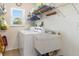 Functional laundry room with washer, dryer, utility sink, and ample storage shelves at 3024 Caribbean Dr, Punta Gorda, FL 33950