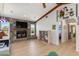 Bright living room features a stone fireplace, ceiling beams, and wood floors at 3024 Caribbean Dr, Punta Gorda, FL 33950