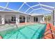 Screened-in pool area features a large pool, spa, brick patio, and covered lounge area at 3024 Caribbean Dr, Punta Gorda, FL 33950