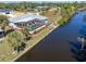 Aerial view of a home featuring a screened-in pool and canal access with lush tropical landscaping at 3024 Caribbean Dr, Punta Gorda, FL 33950