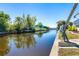 Enjoy peaceful waterfront views with lush landscaping and calming waters reflecting the sky at 3024 Caribbean Dr, Punta Gorda, FL 33950