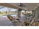 Large, covered patio with ceiling fans, a dining area, seating, and views of the pool and backyard at 321 Pessoa St, Punta Gorda, FL 33983
