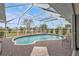 Screened-in pool area with wood-look decking, a table, and views of the backyard at 321 Pessoa St, Punta Gorda, FL 33983