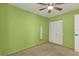 Neutral carpeted bedroom features bright green walls, a lighted ceiling fan, and closet at 346 Cypress Nw Ave, Port Charlotte, FL 33952