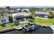 Aerial view of waterfront property featuring a boat lift, pool, and screened-in lanai, ideal for outdoor living at 3906 Crooked Island Dr, Punta Gorda, FL 33950