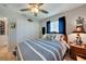 Comfortable bedroom with striped bedding, a ceiling fan, and closet storage space at 3906 Crooked Island Dr, Punta Gorda, FL 33950