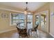 Bright breakfast nook features a glass-top table, floral chairs and pool views at 3961 San Pietro Ct, Punta Gorda, FL 33950