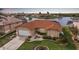 Inviting exterior of a waterfront home with a well-maintained lawn and landscaping, complemented by a terracotta tile roof at 3961 San Pietro Ct, Punta Gorda, FL 33950