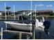 The white boat is on a lift on the canal, with houses along the water in the background at 413 Valletta Ct, Punta Gorda, FL 33950