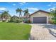 Beautiful single-story home with a lush front lawn, mature trees, and a convenient two-car garage at 413 Valletta Ct, Punta Gorda, FL 33950