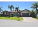 Single-story home with a two car garage, mature landscaping and a well-manicured lawn at 413 Valletta Ct, Punta Gorda, FL 33950