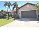 Charming single-story home featuring a well-manicured lawn, beautiful palm trees, and a brick-paved driveway at 413 Valletta Ct, Punta Gorda, FL 33950