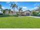 Charming single-story home featuring a well-manicured lawn, mature palm trees, and a two-car garage at 413 Valletta Ct, Punta Gorda, FL 33950