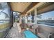 Screened lanai with waterfront views, featuring seating and a small accent table at 413 Valletta Ct, Punta Gorda, FL 33950