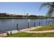 Scenic waterfront view with a seawall, boat dock, and a sailboat, showcasing the property's access to water activities at 413 Valletta Ct, Punta Gorda, FL 33950