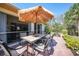 Inviting patio with dining table, chairs, and shade umbrella, overlooking the lush backyard at 468 Paramaribo St, Punta Gorda, FL 33983