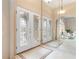 Elegant foyer featuring decorative glass front doors, tile flooring, and mirrored wall at 5032 La Costa Island Ct, Punta Gorda, FL 33950