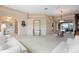 Spacious living room with white sofas, glass shelving, and access to the lanai at 5032 La Costa Island Ct, Punta Gorda, FL 33950