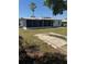 A view of the spacious backyard with an outdoor slab, screened in porch and mature tree at 5100 Bullard St, North Port, FL 34287
