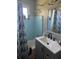 Bright bathroom with blue tile shower, updated vanity, and decorative seashell shower curtain at 5100 Bullard St, North Port, FL 34287