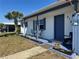 Charming home with blue accents, a palm tree, and a cozy front porch at 5100 Bullard St, North Port, FL 34287