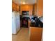Efficient kitchen with wood cabinets, black appliances, and tile flooring at 5100 Bullard St, North Port, FL 34287
