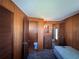 Cozy bedroom with wood-paneled walls, a vintage dresser, and a private half bathroom at 6830 Pleasant Ct, North Port, FL 34287