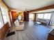 Bright living room with natural light featuring wood paneled walls, hardwood floors, and comfortable seating at 6830 Pleasant Ct, North Port, FL 34287