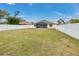 Grassy backyard with screen lanai and surrounding privacy fence at 7804 Mikasa Dr, Punta Gorda, FL 33950