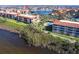 Panoramic aerial view of a condo complex next to a lake, highlighting a pool and surrounding trees at 93 Vivante Blvd # 9323, Punta Gorda, FL 33950