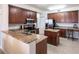 Well-lit kitchen featuring granite countertops, stainless steel appliances, and cherry wood cabinets at 93 Vivante Blvd # 9323, Punta Gorda, FL 33950