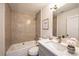 Well-lit bathroom featuring tiled shower over tub, a white vanity with speckled countertop, and modern fixtures at 11401 2Nd Ave, Punta Gorda, FL 33955