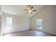 Bright bedroom with two windows, hardwood floors, and a ceiling fan at 11401 2Nd Ave, Punta Gorda, FL 33955