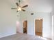 Bright bedroom features vaulted ceiling with fan, light wood floor and access to bathroom and closet at 11401 2Nd Ave, Punta Gorda, FL 33955