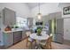 Well-lit kitchen featuring gray cabinets, stainless steel appliances, white marble countertops, and a round dining table with seating for four at 11401 2Nd Ave, Punta Gorda, FL 33955